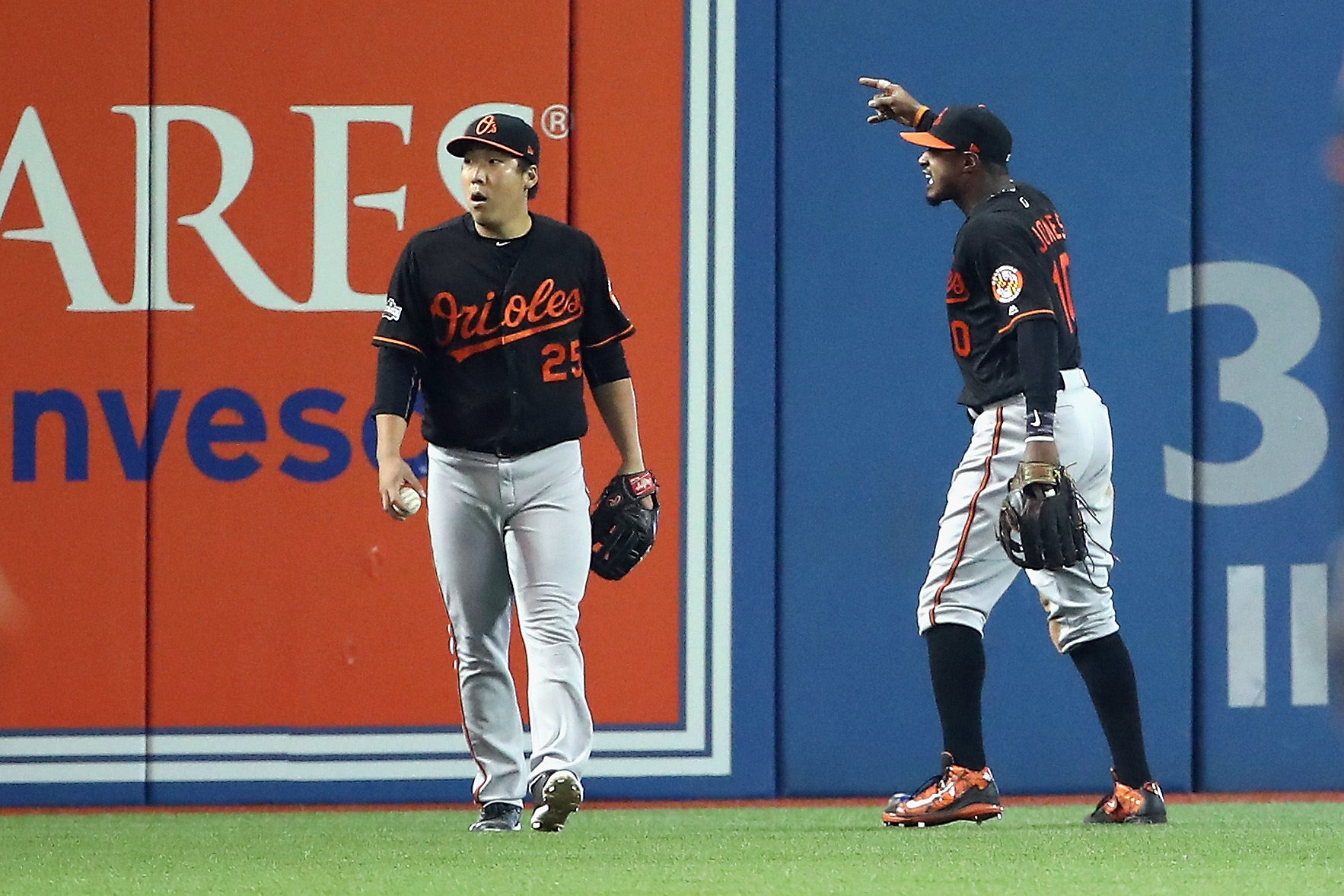 TORONTO ON- OCTOBER 04 Hyun Soo Kim #25 of the Baltimore Orioles and Adam Jones #10 react in the seventh inning after a fan threw a beverage onto the field during the American League Wild Card game against the Toronto Blue Jays at Rogers Centre on Oct