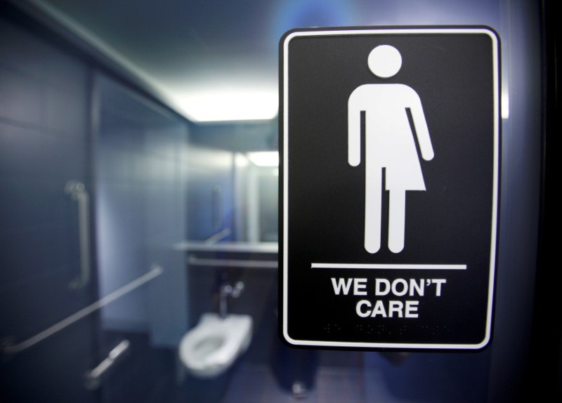 A sign protesting a recent North Carolina law restricting transgender bathroom access is seen in the bathroom stalls at the 21C Museum Hotel